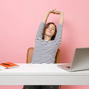 a woman stretching at her desk