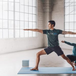 a female instructor showing a man how to do a yoga pose