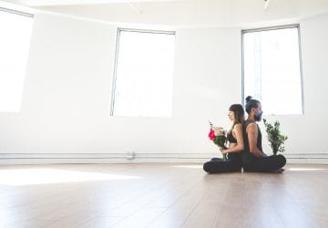 a couple sitting in a brightly lit room facing away from each other