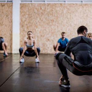 a group doing deep squat stretches