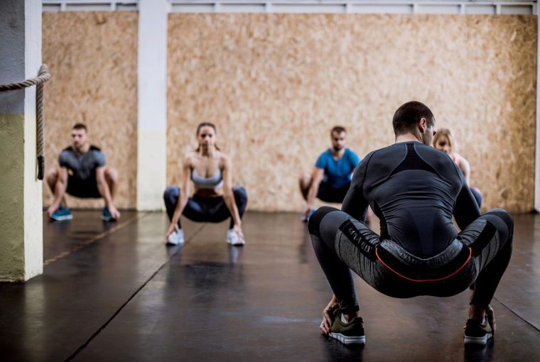 a group doing deep squat stretches