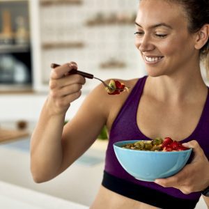 a woman eating a bowl of healthy food