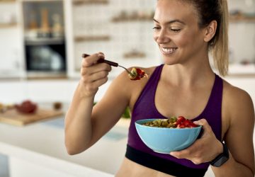 a woman eating a bowl of healthy food