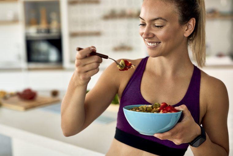 a woman eating a bowl of healthy food