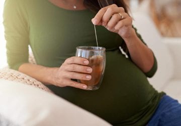a pregnant woman having a cup of tea
