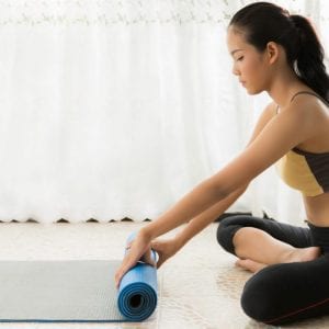 Woman rolling yoga mat