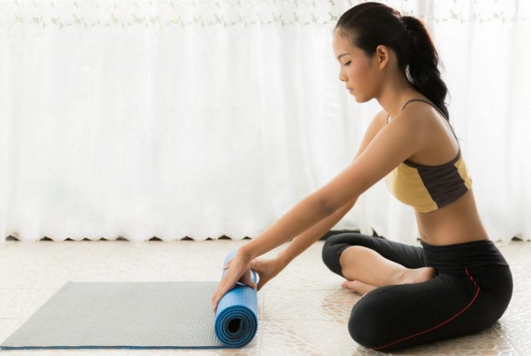 Woman rolling yoga mat
