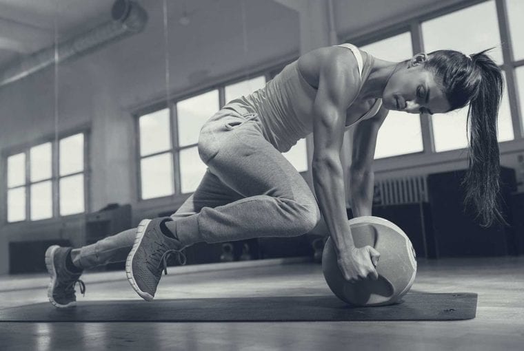 womon doing exercise on the floor with an exercise ball