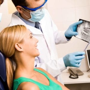 woman looking at panoramic x-ray with her dentist