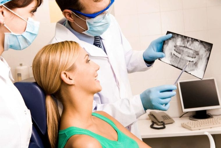 woman looking at panoramic x-ray with her dentist