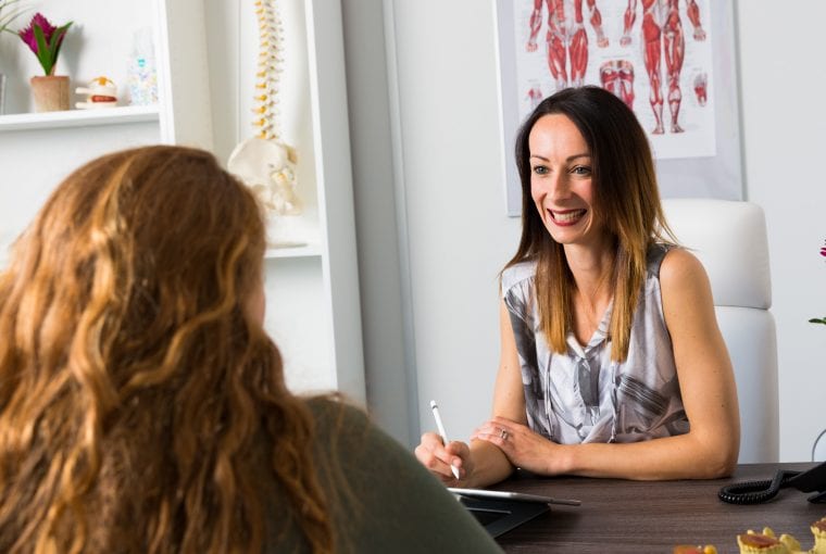women sitting at desk talking