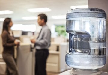 people standing in an office around a water cooler