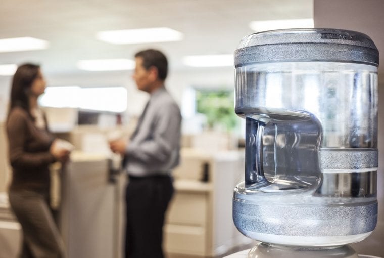 people standing in an office around a water cooler