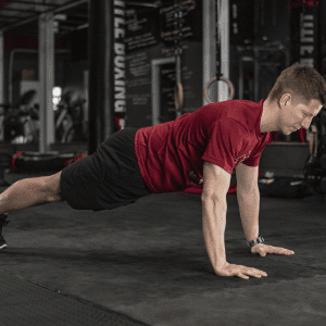 man doing a plank exercise in the gym
