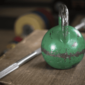 a kettlebell and olympic bar sitting on a bench