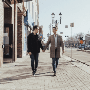 gay couple holding hands walking down a street
