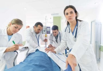 medical professionals in an ER room working on a patient