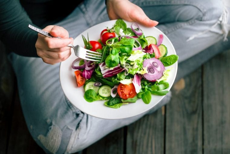 person sitting on the floor eating a healthy diet