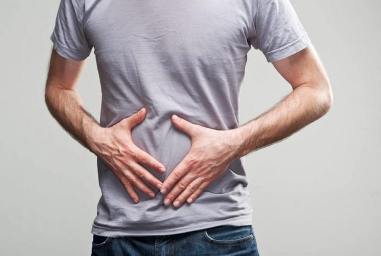 man holding hands over his stomach