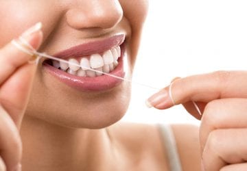 Cleaning teeth with dental floss, perfect healthy tooth