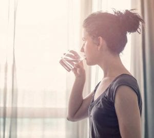 woman drinking a glass of water in the morning
