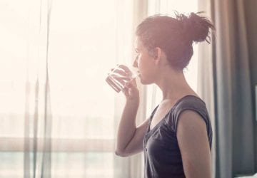 woman drinking a glass of water in the morning