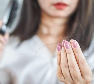 woman pulling hair out of her hair brush