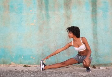 woman stretching in front of a wall