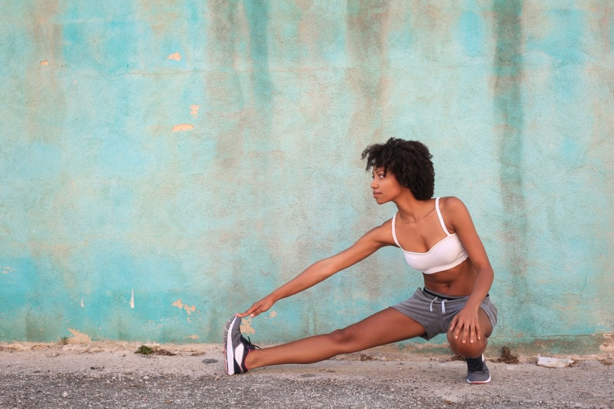 woman stretching in front of a wall