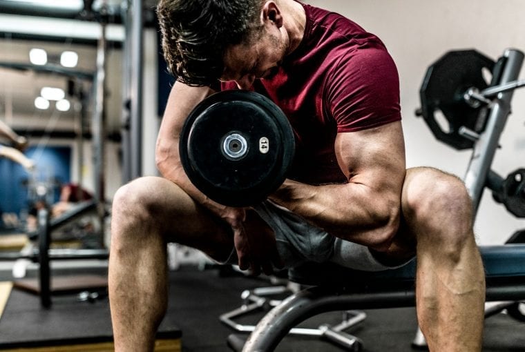 man doing arm curls with dumbell