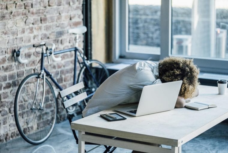 woman falling asleep at her desk in the office