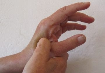 person applying pressure at acupressure point on hand