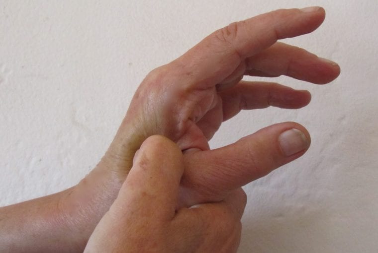 person applying pressure at acupressure point on hand