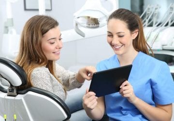 woman looking at her medical chart with her dentist