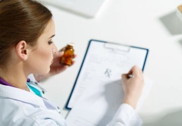 doctor going over a patient chart holding medication