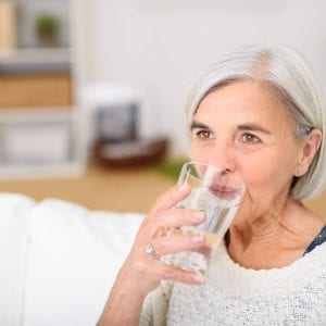 older woman drinking a glass of water