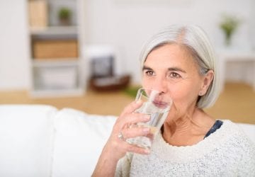 older woman drinking a glass of water