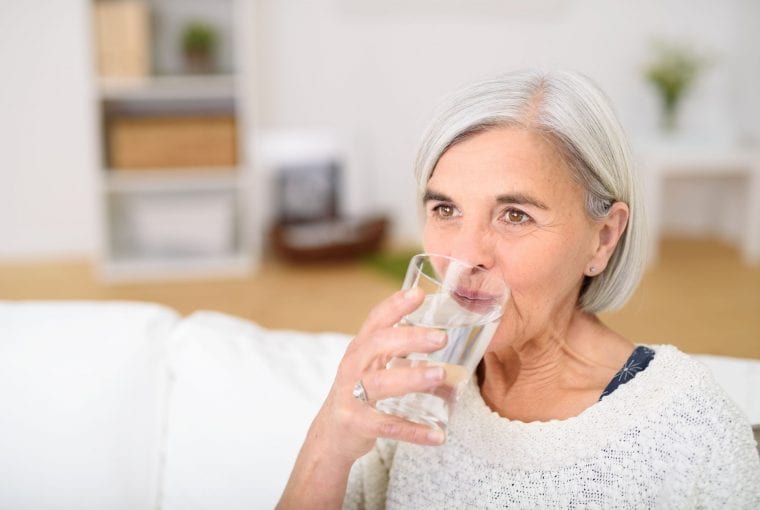 older woman drinking a glass of water