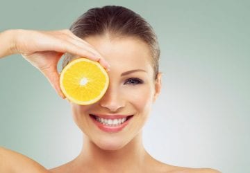 woman with great skin holding an orange
