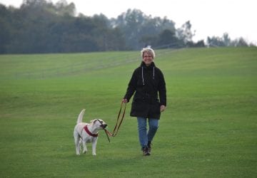 woman walking with her dog outdoors
