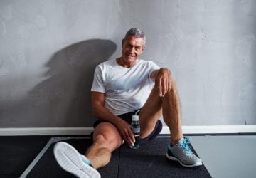 athletic man sitting on the floor smiling
