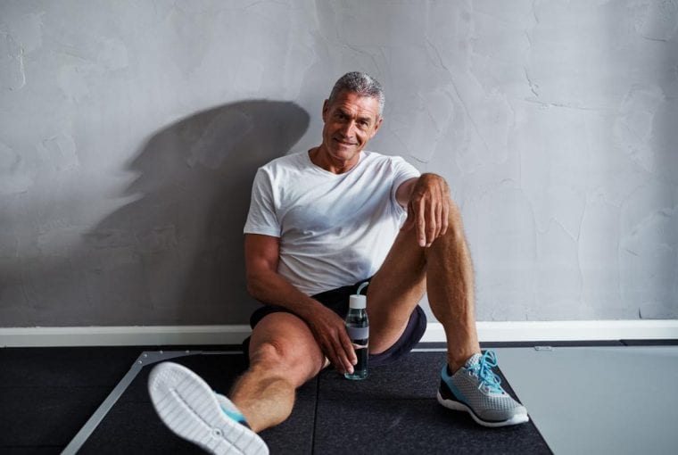 athletic man sitting on the floor smiling
