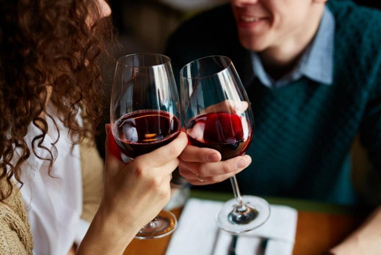 a couple enjoying a glass of red wine