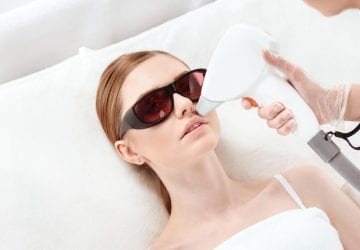 woman receiving laser hair removal on her face
