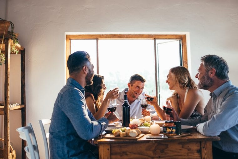 a group of people socializing around the dinner table