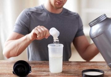man taking a scoop of protein powder