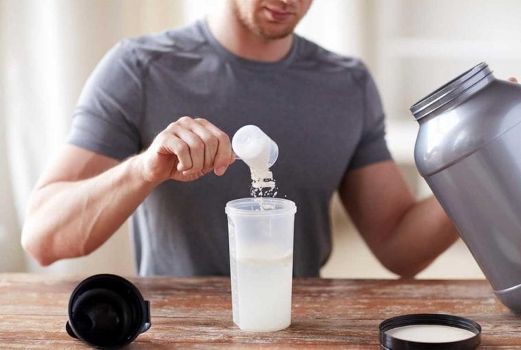 man taking a scoop of protein powder