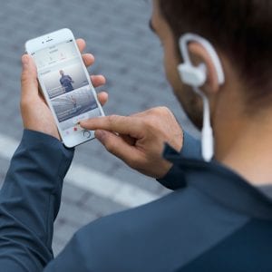 A man checking his iPhone while going for a run