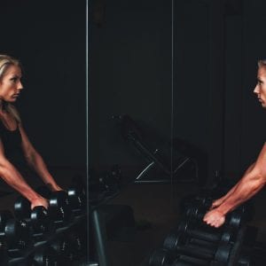 athletic woman working out in front of a mirror