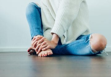 woman sitting barefoot on the floor